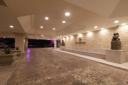 - un hall avec un sol en pierre et un mur éclairé dans l'établissement MS Milenium Monterrey Curio Collection by Hilton, à Monterrey