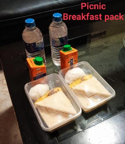 a table with two plastic containers of food and bottles of water at Ayubowan Homestay Katunayake in Katunayake