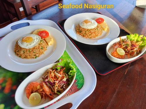 three plates of food on a table with rice and eggs at Ayubowan Homestay Katunayake in Katunayake