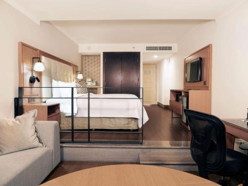 a hotel room with a bed and a couch at MS Milenium Monterrey Curio Collection by Hilton in Monterrey