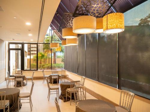 a restaurant with tables and chairs and a chalkboard at MS Milenium Monterrey Curio Collection by Hilton in Monterrey