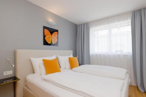 a bedroom with two beds and a window with a butterfly picture at RAFAEL KAISER - Premium Apartments City Centre - Contactless Check-In in Vienna