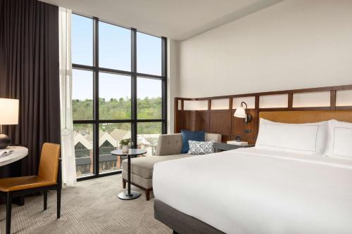 a hotel room with a bed and a large window at Valley Hotel Homewood Birmingham - Curio Collection By Hilton in Birmingham