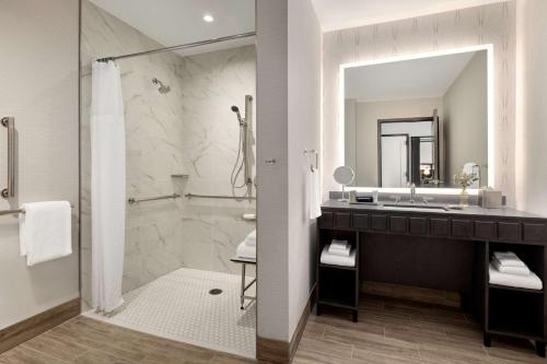 a bathroom with a sink and a large mirror at Valley Hotel Homewood Birmingham - Curio Collection By Hilton in Birmingham