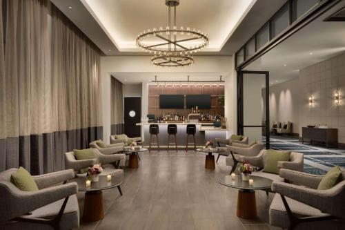 a lobby with couches and tables and a bar at Valley Hotel Homewood Birmingham - Curio Collection By Hilton in Birmingham
