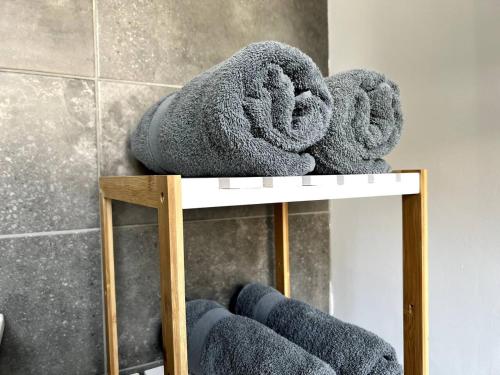 une pile de serviettes assises sur une étagère dans une salle de bains dans l'établissement Appartement Turquoise - 2 pers - Sedan, à Sedan
