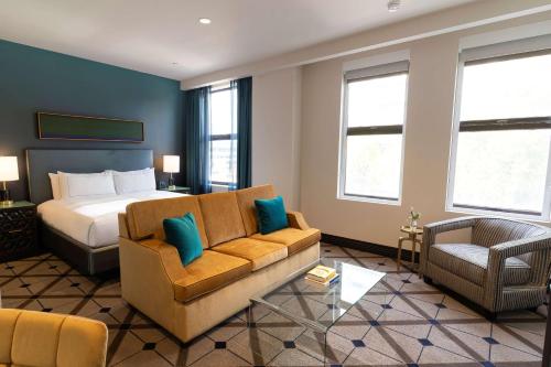 um quarto de hotel com uma cama e um sofá em The Exchange Sacramento, Curio Collection By Hilton em Sacramento