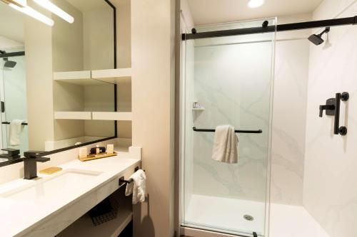 y baño con ducha y lavamanos. en The Exchange Sacramento, Curio Collection By Hilton en Sacramento