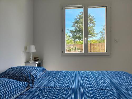 une chambre avec un lit bleu et une fenêtre dans l'établissement La tranquille escale, à Bretignolles-sur-Mer