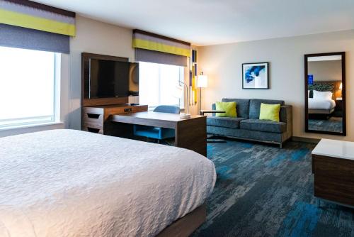 a hotel room with a bed and a desk and a couch at Hampton Inn Paris IL, IL in Paris