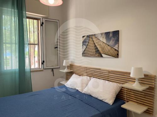 トッレ・ラピッロにあるVilla Auroraのベッドルーム(青いベッド1台、窓付)