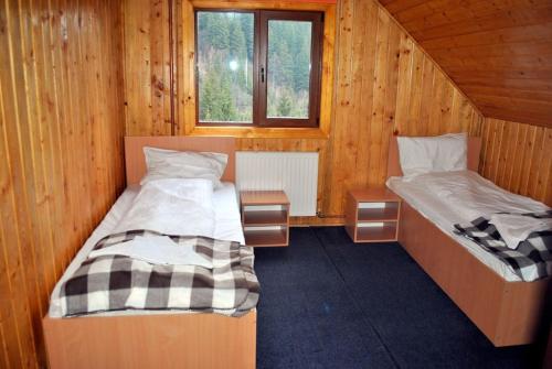 Duas camas num quarto com paredes de madeira em Vila Artemis em Rausor