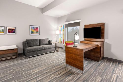 a living room with a couch and a flat screen tv at Hampton Inn & Suites Tigard in Tigard