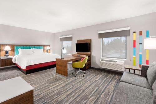 タイガードにあるHampton Inn & Suites Tigardのベッドとデスクが備わるホテルルームです。