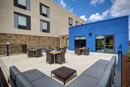 a patio with tables and chairs in front of a building at Hampton Inn Cave City, KY in Cave City