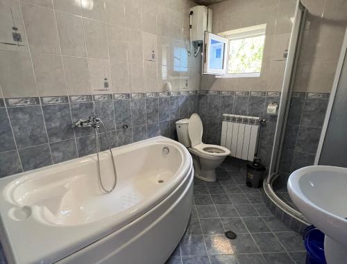 a bathroom with a tub and a toilet and a sink at Vacation Home Yoanna in Tryavna
