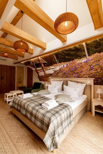 a bedroom with a large bed with flowers on the wall at Ku Dolinie in Kościelisko