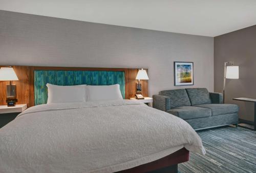 une chambre d'hôtel avec un lit et un canapé dans l'établissement Hampton Inn Cave City, KY, à Cave City
