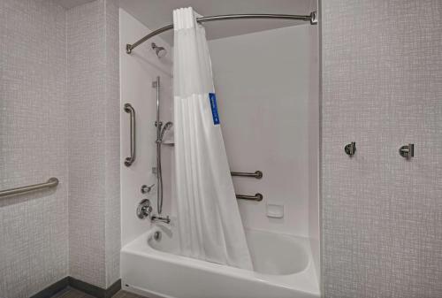 um chuveiro com uma cortina de chuveiro branca na casa de banho em Hampton Inn Cave City, KY em Cave City