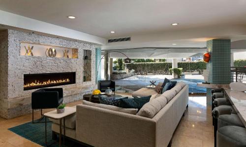 a living room with a couch and a fireplace at The Belamar Hotel Manhattan Beach, Tapestry by Hilton in Manhattan Beach