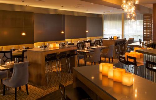 un restaurante con mesas y sillas en una habitación en The Belamar Hotel Manhattan Beach, Tapestry by Hilton, en Manhattan Beach