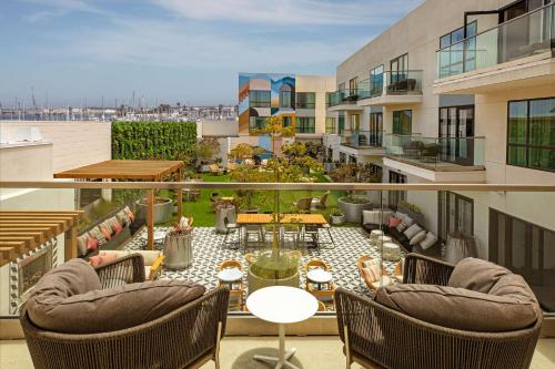 a balcony with chairs and tables on a building at The Monsaraz San Diego, Tapestry Collection By Hilton in San Diego