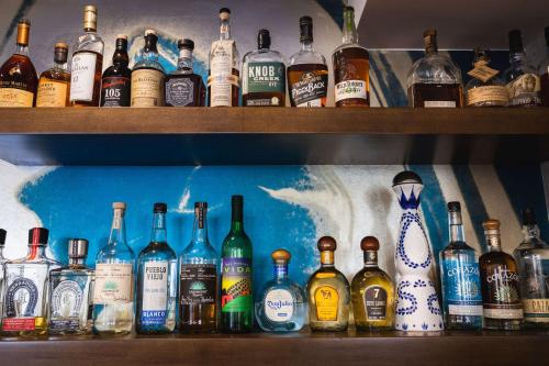 a shelf filled with lots of bottles of alcohol at Redondo Beach Hotel, Tapestry Collection by Hilton in Redondo Beach