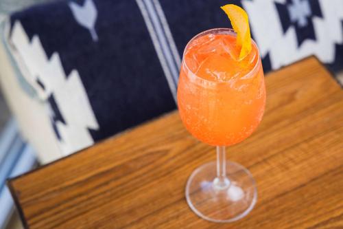 a drink in a glass sitting on a wooden table at Redondo Beach Hotel, Tapestry Collection by Hilton in Redondo Beach