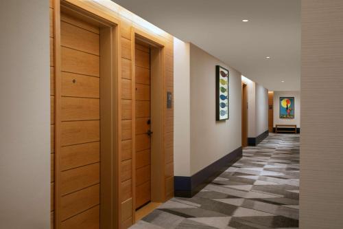 a hallway with wooden doors and a checkered floor at The Monsaraz San Diego, Tapestry Collection By Hilton in San Diego
