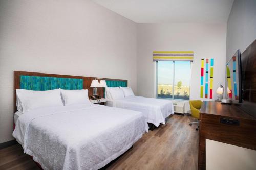 a hotel room with two beds and a window at Hampton Inn Riverside March Air Force Base, Ca in Riverside