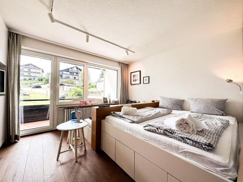 1 dormitorio con cama y ventana grande en GreenHill 2 - mit Privatsauna en Oberstaufen