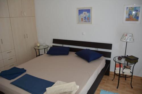 a bedroom with a large bed with blue pillows at MARINA apartment in Tinos Town