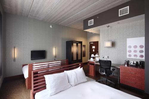 a bedroom with a bed and a desk and a chair at Tulyp, Tapestry Collection by Hilton in Holland