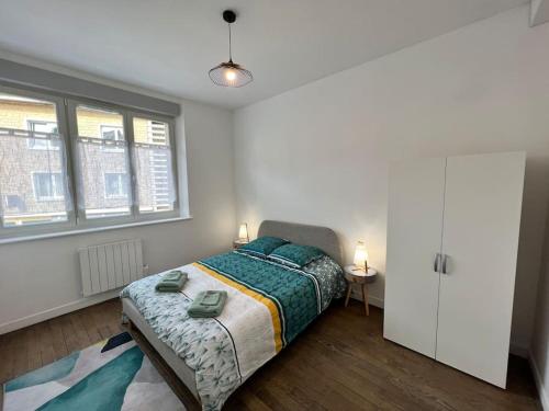 a bedroom with a bed and two windows at Appartement Rubis - 2 pers - Sedan in Sedan