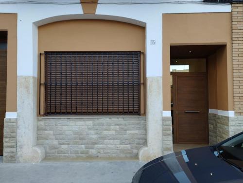 un edificio con una puerta y una puerta de madera en Casa vacacional El Sol, en Turís