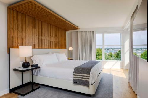 a bedroom with a white bed and a large window at Canopy By Hilton Portland Waterfront in Portland