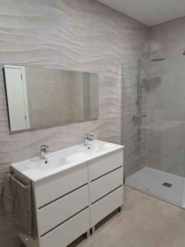 a white bathroom with a sink and a shower at Casa vacacional El Sol in Turís