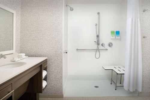 a bathroom with a shower and a sink at Home2 Suites by Hilton Orlando Downtown, FL in Orlando