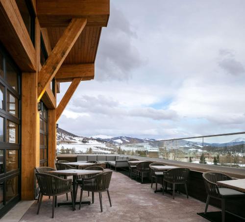 a balcony with tables and chairs and a view of the mountains at Homewood Suites By Hilton Dillon in Dillon
