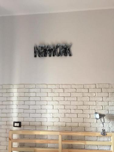 a sign on a wall above a wooden bench at Sweet Rome B&B in Rome