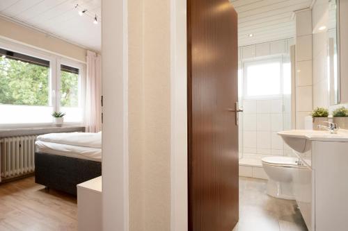 uma casa de banho com um WC, um lavatório e uma cama em Haus Sonneninsel Wohnung 5 em Grömitz