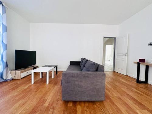 a living room with a couch and a table at Spacieux et Lumineux in Saint-Claude