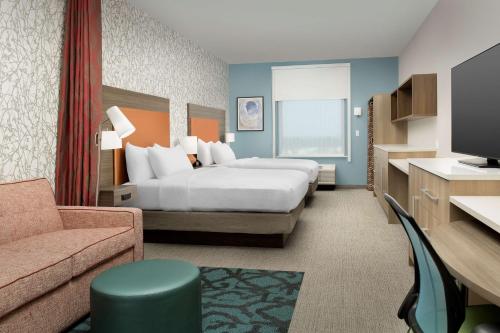 a hotel room with a bed and a couch at Home2 Suites By Hilton Tampa Westshore Airport, Fl in Tampa