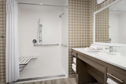 a bathroom with a shower and a sink and a mirror at Home2 Suites By Hilton Tampa Westshore Airport, Fl in Tampa