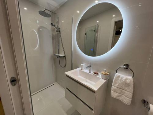 La salle de bains blanche est pourvue d'un lavabo et d'un miroir. dans l'établissement Murter Luxury Penthouse with Sea View for two, à Murter