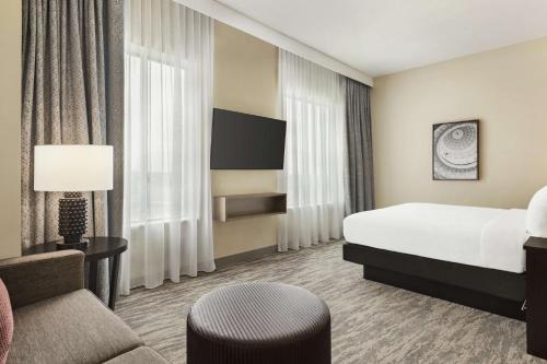 Embassy Suites by Hilton Round Rock في راوند روك: غرفه فندقيه بسرير وكرسي