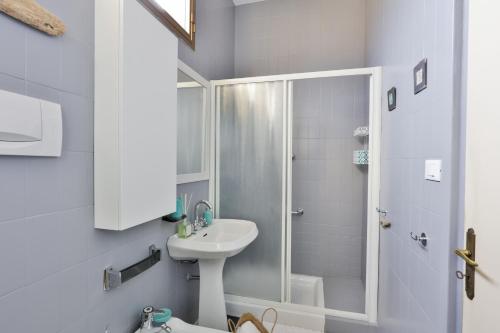 a white bathroom with a shower and a sink at Riviera dei friori in Bordighera