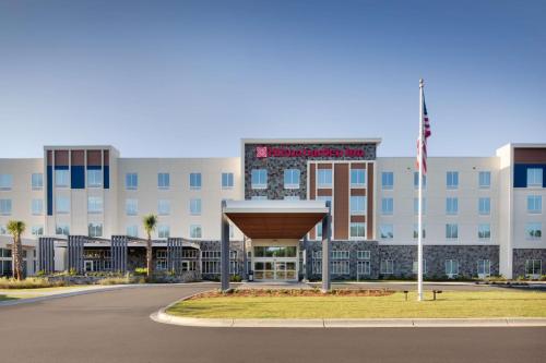 a hospital building with an american flag in front of it at Hilton Garden Inn Panama City Airport, Fl in Panama City