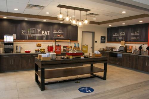 a large kitchen with a counter in a restaurant at Hampton Inn & Suites Olean, Ny in Olean