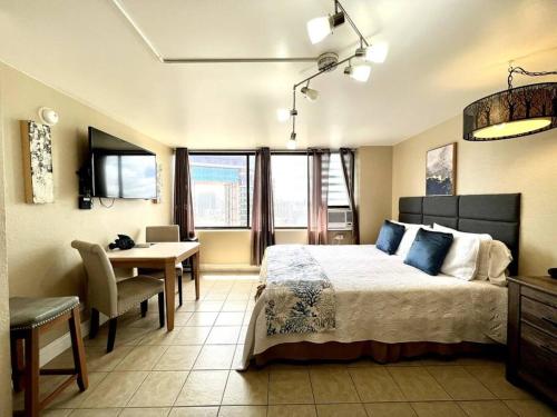 1 dormitorio con cama, mesa y escritorio en KING BED, Spacious, Legal, VIEW en Honolulu